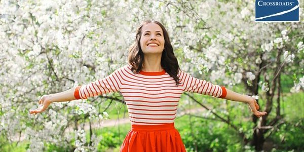 _CR_BLOG1.WomensHealth woman smiling in blooming trees empowered to overcome addiction