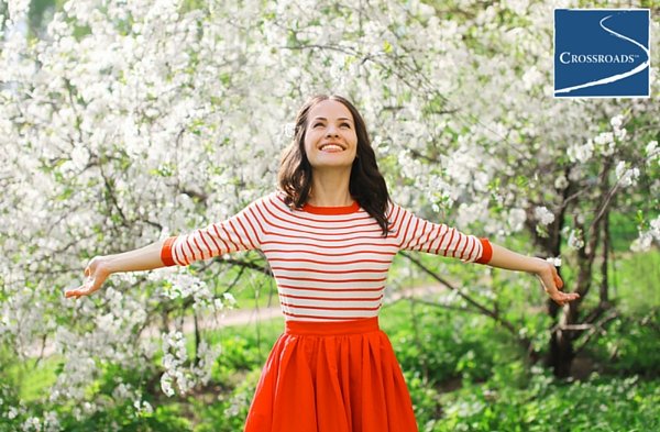 _CR_BLOG1.WomensHealth woman smiling in blooming trees empowered to overcome addiction