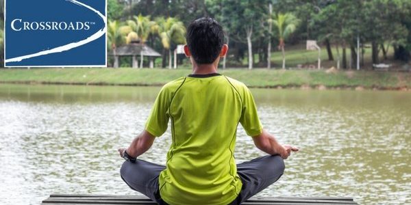 holistic-healing-young-man-doing-yoga-crblog3 man using holistic meditation yoga on a dock to enhance addiction treatment healing