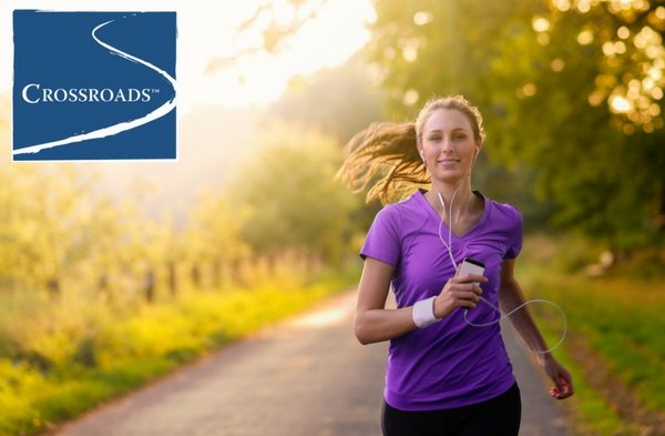 woman staying positive in recovery by jogging outside and listening to music