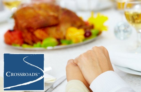 embracing hands in gratitude at Thanksgiving meal