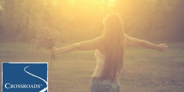 forgiveness-happy-free-woman-crblog1 woman holding flowers and embracing the sun to start the year off fresh