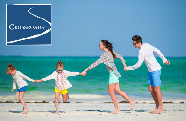 family pulling each other along on the beach to overcome bad days on vacation