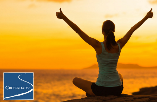 woman caring for herself with outdoor yoga at Crossroads