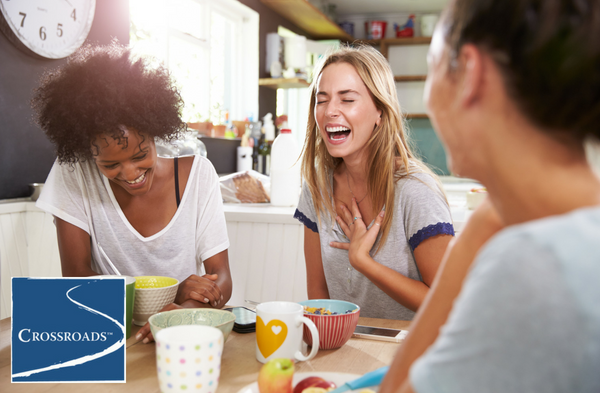 women laughing over breakfast at Crossroads residential treatment program
