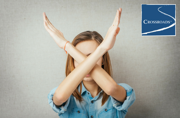 young woman crossing arms in an X to say no to boredom in recovery