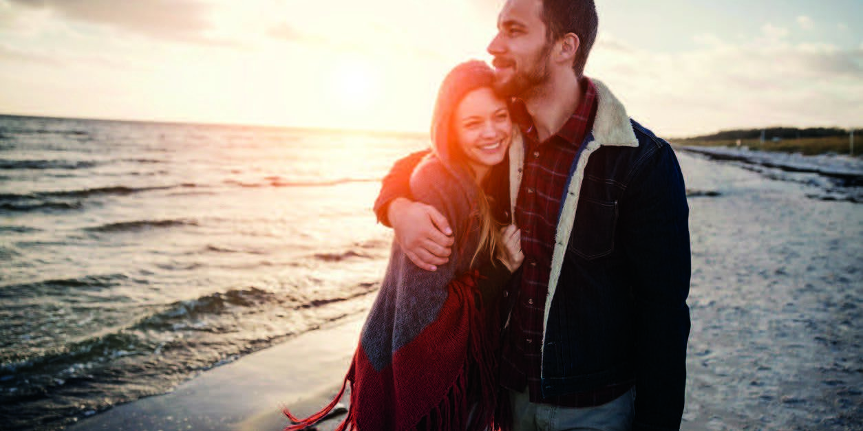 Falmouth_Cumberland_Crossroads husband hugging smiling wife during walk on beach after recovery from mental health and substance use at Crossroads