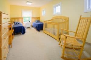 twin bedroom with crib at children and mothers residential program