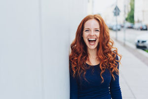 a woman smiling on the street as she has found a bulimia treatment center