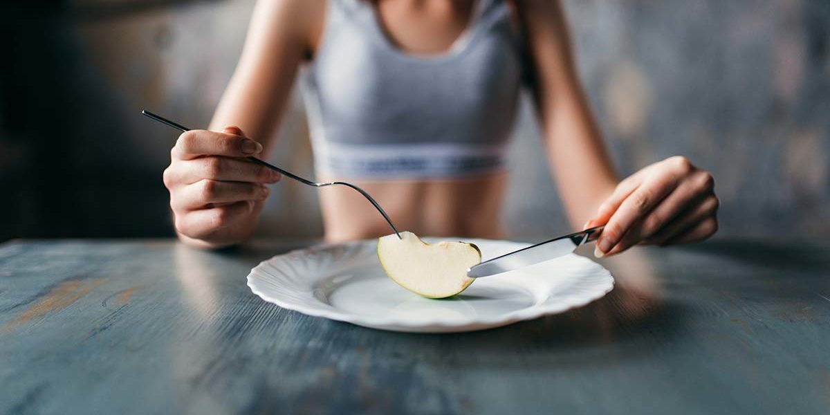 woman staring at food wondering about anorexia vs bulimia