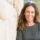 middle aged woman smiling next to rock wall because of benefits of residential treatment