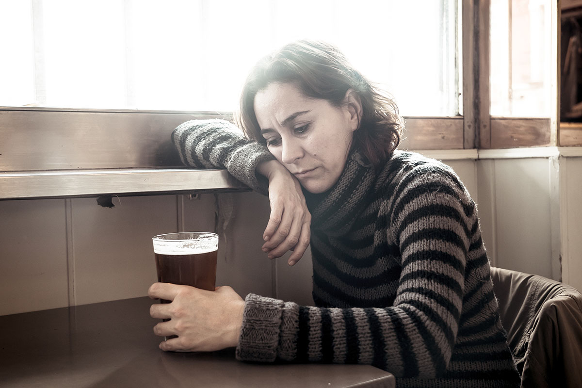 alcohol and depression a woman stares at a beer and thinks about alcohol and depression