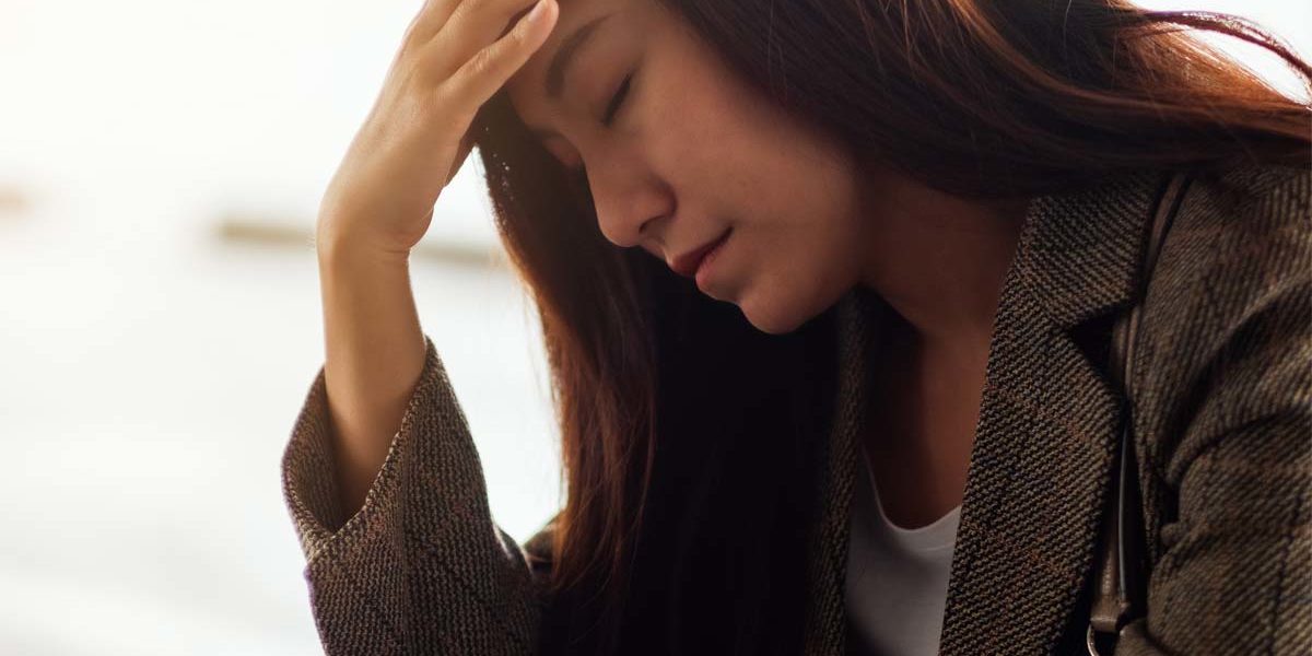 anxiety-and-alcohol a woman puts her head in her hand as she struggles with anxiety and alcohol