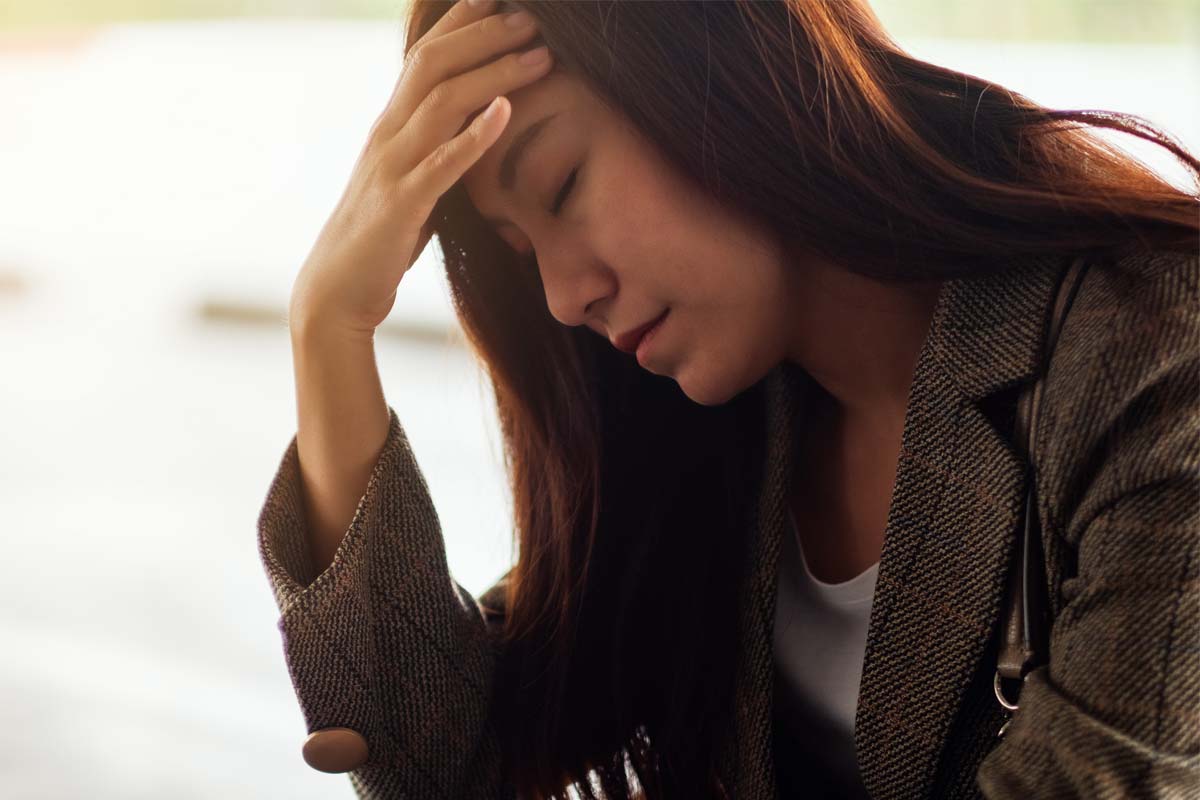 anxiety-and-alcohol a woman puts her head in her hand as she struggles with anxiety and alcohol