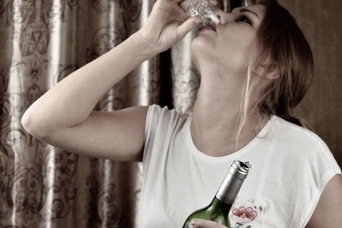 dangers of alcohol addiction a woman drinks and thinks about the dangers of alcohol addiction