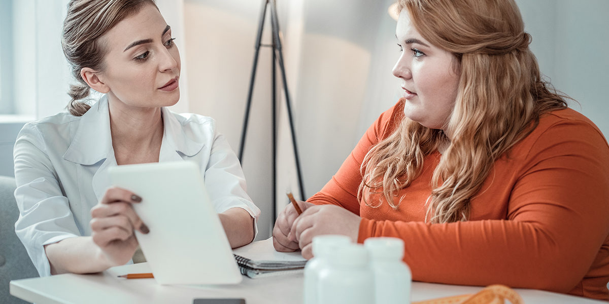 a woman discusses the eating disorder definition with her doctor