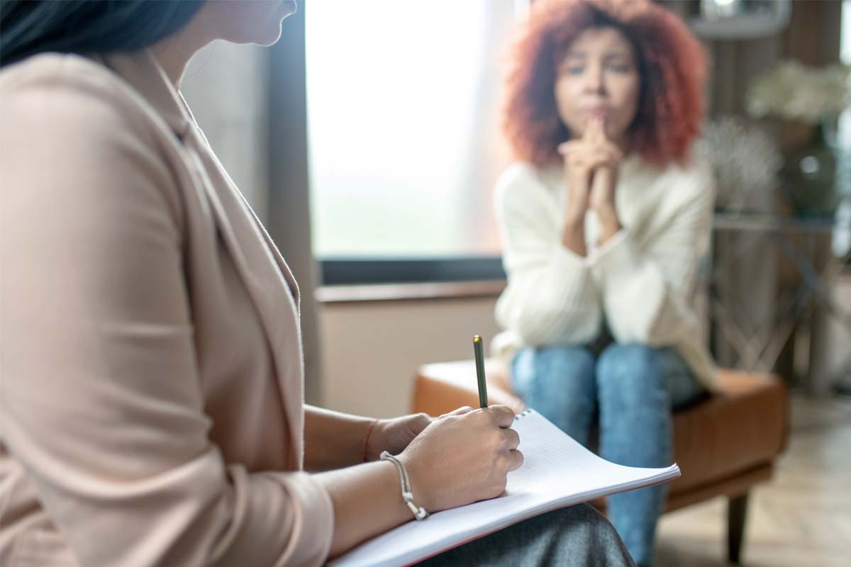 treatment-program-for-addiction a woman talks to her therapist about attending a treatment program for addiction