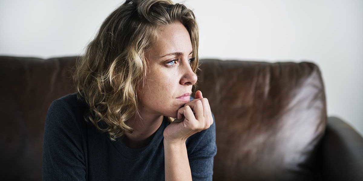 triggers of alcohol abuse a woman sits on the couch as she considers the triggers of alcohol abuse