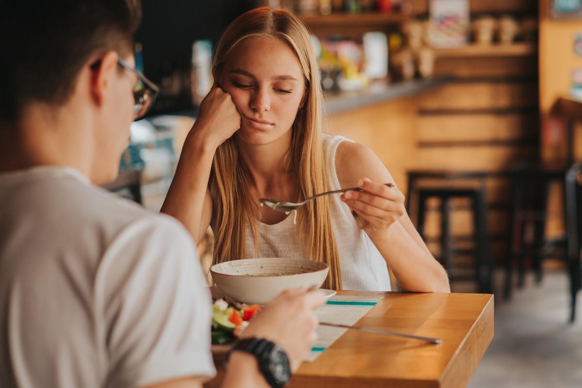 a woman sits with a friend as she struggles with the effects of eating disorders