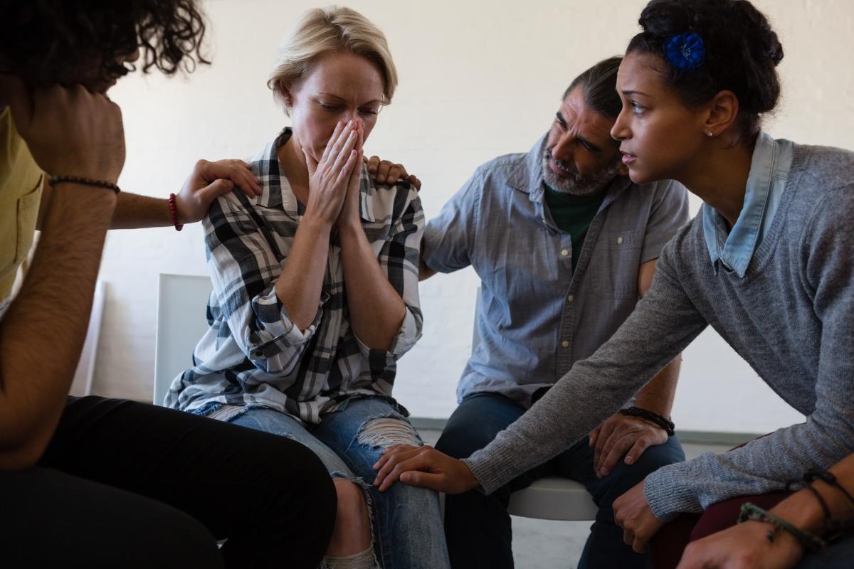 Alcohol Addiction Quotes to Help You in Times of Need a group of people comfort a young woman with alcohol addiction quotes