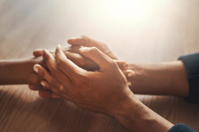How to Help Someone With Anxiety two people holding hands learning how to help someone with anxiety