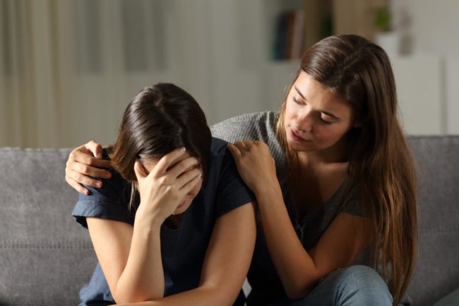 How to Help Someone With Bipolar Disorder a woman consoling her woman friend and demonstrating how to help someone with bipolar disorder